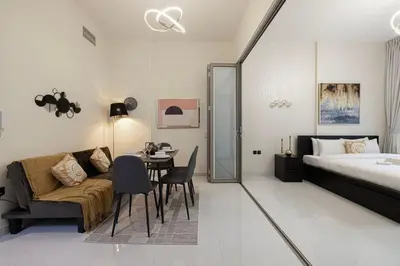 a bedroom with a bed and a table and a couch at Stylish pool view 1BR in Barsha South sleeps 5 in Dubai