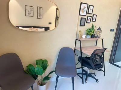 two chairs and a table in a room with a mirror at Stylish pool view 1BR in Barsha South sleeps 5 in Dubai