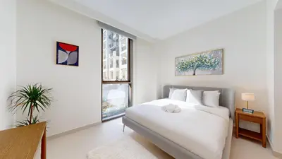 a white bedroom with a bed and a window at Vacationer l Contemporary 2 Bedroom l Pool, Gym, Private Beach Access in Dubai