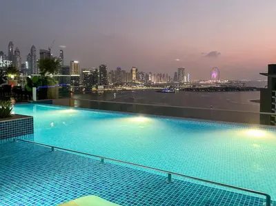 a swimming pool on top of a building with a city skyline at Luxury studio with beach and pool access. in Dubai