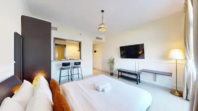 a large room with a bed and a kitchen at Vacationer l Spacious Studio l Canal View l The Greens in Dubai