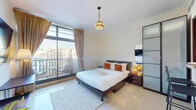 a bedroom with a bed and a large window at Vacationer l Spacious Studio l Canal View l The Greens in Dubai