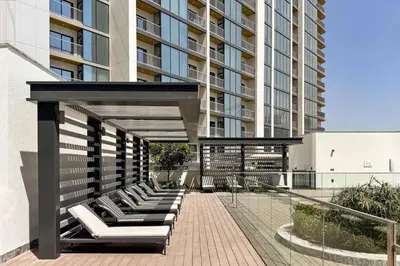 a group of lounge chairs on a balcony of a building at Modern 1BR with Guest Room l Sobha Hartland The Crest Tower C in Dubai