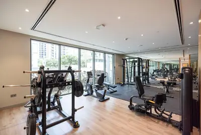 a gym with several treadmills and machines in a building at Modern 1BR with Guest Room l Sobha Hartland The Crest Tower C in Dubai