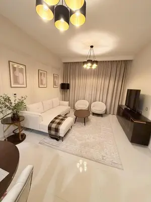 a living room with a white couch and a tv at Luxury Living in JVC 1BR Apartment in Dubai