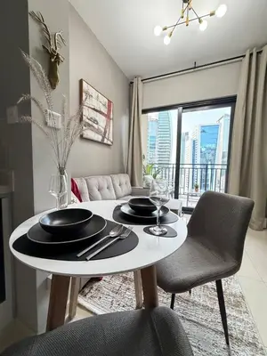a dining room with a table and chairs and a room with a window at Zada Tower 1 Bedroom Apartment in Business Bay in Dubai