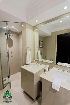 a bathroom with a sink and a large mirror at Full View Burj Khalifa and Fountains -Souk Al Bahar- Dream View holiday Home Rent in Dubai