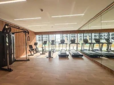 a gym with a row of treadmills and a large window at Frank Porter - Azizi Mirage 1 in Dubai