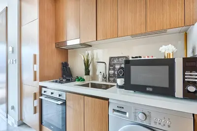 a kitchen with a microwave and a sink at Frank Porter - Azizi Mirage 1 in Dubai