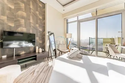 a living room with a tv and a large window at Sleek Modern Studio with Direct view of Dubai Skyline - Farhad Azizi Residence, Al Jaddaf by Deluxe Holiday Homes in Dubai