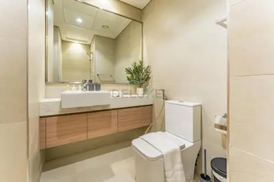 a bathroom with a sink and a toilet and a mirror at Sleek Modern Studio with Direct view of Dubai Skyline - Farhad Azizi Residence, Al Jaddaf by Deluxe Holiday Homes in Dubai