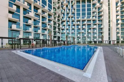 a swimming pool in front of a building at Sleek Modern Studio with Direct view of Dubai Skyline - Farhad Azizi Residence, Al Jaddaf by Deluxe Holiday Homes in Dubai