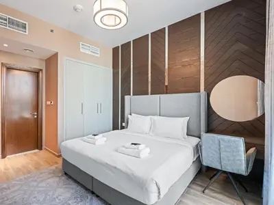 a bedroom with a large bed and a chair at Cozy and Elegant 1 BDR In Noura Tower-37 in Dubai