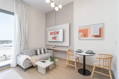a living room with a couch and a table at StayShort - Spacious Studio in Town Square Sleeps 2 in Nadd Shubayḩ