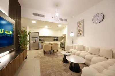 a living room with a couch and a tv at Silk Valley - Green View Oasis: Stylish 2BR in Dubai’s Town Square in Dubai