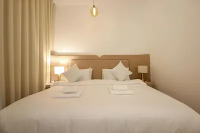 a bedroom with a white bed with two towels on it at Silk Valley - Green View Oasis: Stylish 2BR in Dubai’s Town Square in Dubai