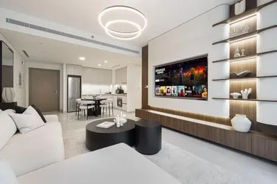 a living room with a white couch and a tv at Beachfront 2BR Marina & Beach Views in Dubai