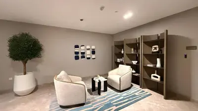 a living room with two chairs and a plant at Beachfront 2BR Marina & Beach Views in Dubai