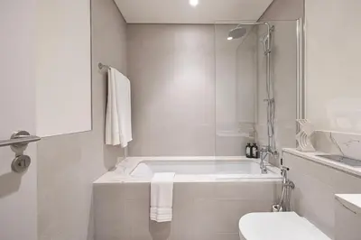 a bathroom with a tub and a toilet and a sink at Beachfront 2BR Marina & Beach Views in Dubai