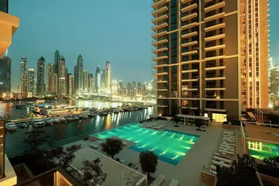 a large swimming pool in the middle of a city at Beachfront 2BR Marina & Beach Views in Dubai