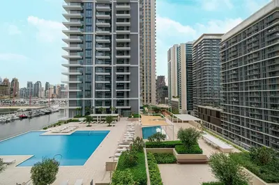 an apartment complex with a swimming pool and tall buildings at Beachfront 2BR Marina & Beach Views in Dubai