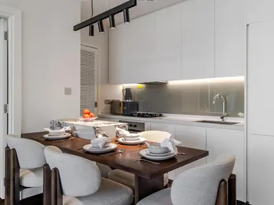 a kitchen with a wooden table and chairs at Stunning High-Floor 1BR Burj Khalifa & Canal Views in Dubai