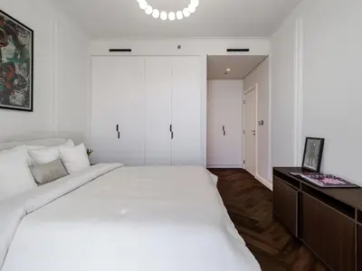 a bedroom with a large white bed and a desk at Stunning High-Floor 1BR Burj Khalifa & Canal Views in Dubai