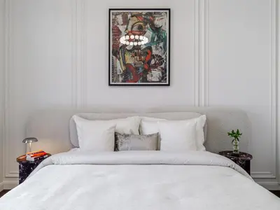 a bedroom with a white bed with a picture above it at Stunning High-Floor 1BR Burj Khalifa & Canal Views in Dubai