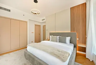a bedroom with a large bed with white sheets at Curated High-Floor 2BR Sofa Bed Marina Water View in Dubai