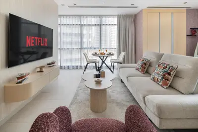 a living room with a couch and a tv at Chic Studio in Sports City Pool, Gym, Sauna in Dubai