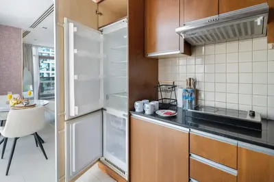 a kitchen with an empty refrigerator and a table at Chic Studio in Sports City Pool, Gym, Sauna in Dubai