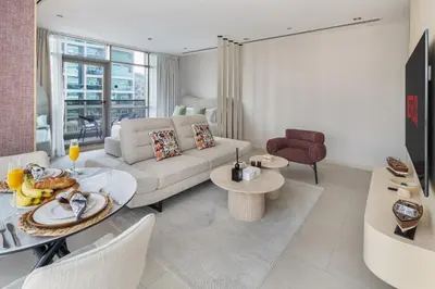 a living room with a couch and a table at Chic Studio in Sports City Pool, Gym, Sauna in Dubai