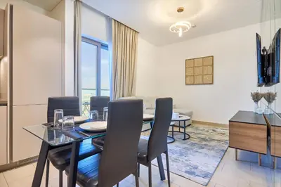 a dining room with a glass table and chairs at STAY BY LATINEM Luxury 1BR Holiday Home CVR A2604 near Burj Khalifa in Dubai