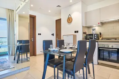 a kitchen and dining room with a table and chairs at STAY BY LATINEM Luxury 1BR Holiday Home CVR A2604 near Burj Khalifa in Dubai