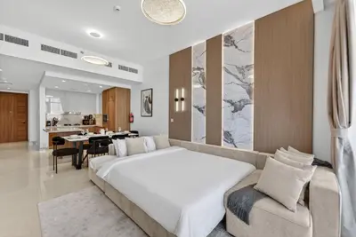 a bedroom with a large white bed and a couch at New Downtown Bldg Near Burj View with Infinity Pool and SkyGym in Dubai