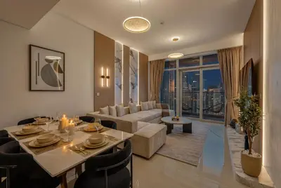 a living room with a table and a couch at New Downtown Bldg Near Burj View with Infinity Pool and SkyGym in Dubai