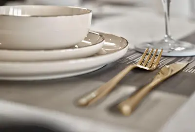a table with two forks and plates and a cup at New Downtown Bldg Near Burj View with Infinity Pool and SkyGym in Dubai