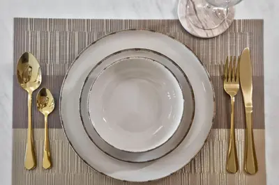 a plate on a table with forks and spoons at New Downtown Bldg Near Burj View with Infinity Pool and SkyGym in Dubai