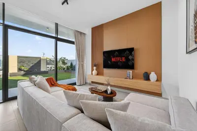 a living room with a couch and a tv at New, Bright & Modern 4BR Villa in Tilal Al Furjan in Dubai