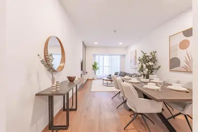 a dining room and living room with a table and chairs at HAVN - 2 bedroom in Elite Residences, Dubai Marina in Dubai