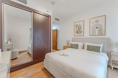 a bedroom with a large white bed and a bathroom at HAVN - 2 bedroom in Elite Residences, Dubai Marina in Dubai