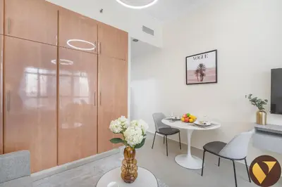 a living room with a table and a dining room at Vogue JLT Lake City Tower near Marina and JBR, Studio Apartment with Lake and City Skyline View, Access to all Amenities in Dubai
