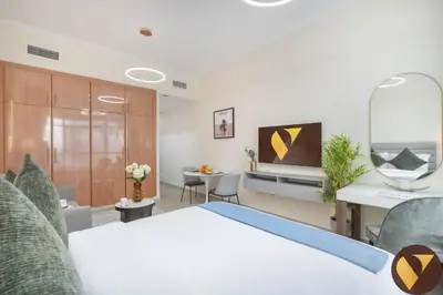 a room with a bed and a table and chairs at Vogue JLT Lake City Tower near Marina and JBR, Studio Apartment with Lake and City Skyline View, Access to all Amenities in Dubai