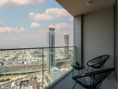 a balcony with two chairs and a view of a city at Exquisite 2BDR Retreat In Forte-33 in Dubai