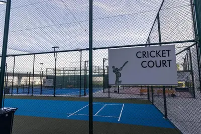 a tennis court with a sign on a fence at Stylish Studio Apartment Skyz by Danube in Dubai