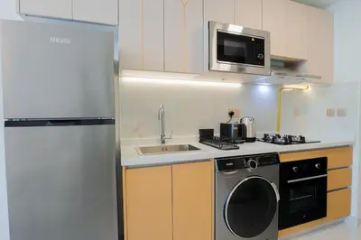 a kitchen with a refrigerator and a sink and a microwave at Stylish Studio Apartment Skyz by Danube in Dubai