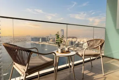 a balcony with a table and chairs and a view at Lux 1BR Beachfront Living Palace Beach Residence in Dubai
