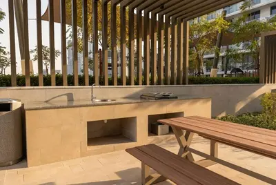a outdoor kitchen with a sink and a wooden bench at Lux 1BR Beachfront Living Palace Beach Residence in Dubai