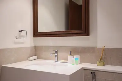a bathroom with a white sink and a mirror at Lux 1BR Beachfront Living Palace Beach Residence in Dubai