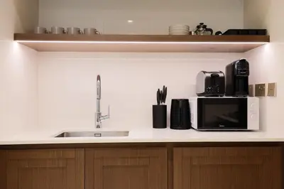 a kitchen counter with a sink and a microwave at Lux 1BR Beachfront Living Palace Beach Residence in Dubai
